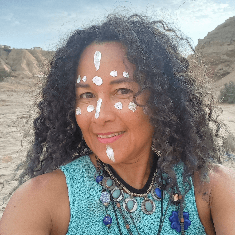 Photo of Luz Olivos, an indigenous woman with long brown hair and white paint on her face.